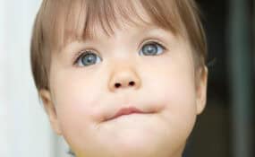 child biting her bottom lip to keep it closed