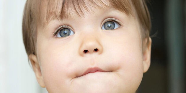 child biting her bottom lip to keep it closed